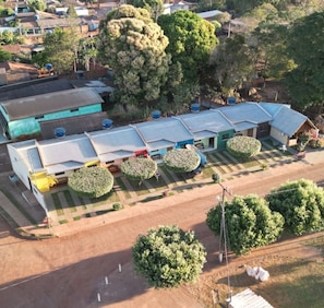 A residential area with multiple houses, a paved road, and well-maintained lawns. - Casa Flor do Ipê Homes (Nobres)