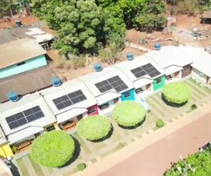 A residential area with multiple houses, some with solar panels, and green lawns. - Casa Flor do Ipê Homes (Nobres)