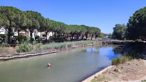 A calm river with a wooden walkway and trees lining the banks. - Studio at the marinas (Saint-Cyprien)