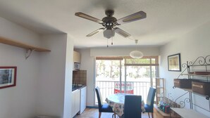 A dining area with a round table, chairs, and a ceiling fan. - Studio at the marinas (Saint-Cyprien)