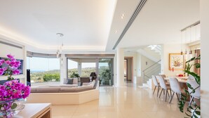 A spacious living area with a large window, a seating area, and a dining space. - Villa Anastasia - Private Pool Panoramic Views (Platanias)