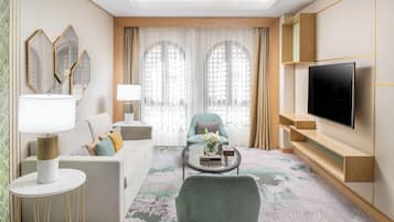 Una sala moderna con sofá, sillón, mesa de centro y televisión.