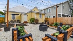 A backyard with outdoor seating, a fire pit, and a wooden fence. - Happy Shack Ybor City-Historic District-Steps to 7th Ave (Tampa)
