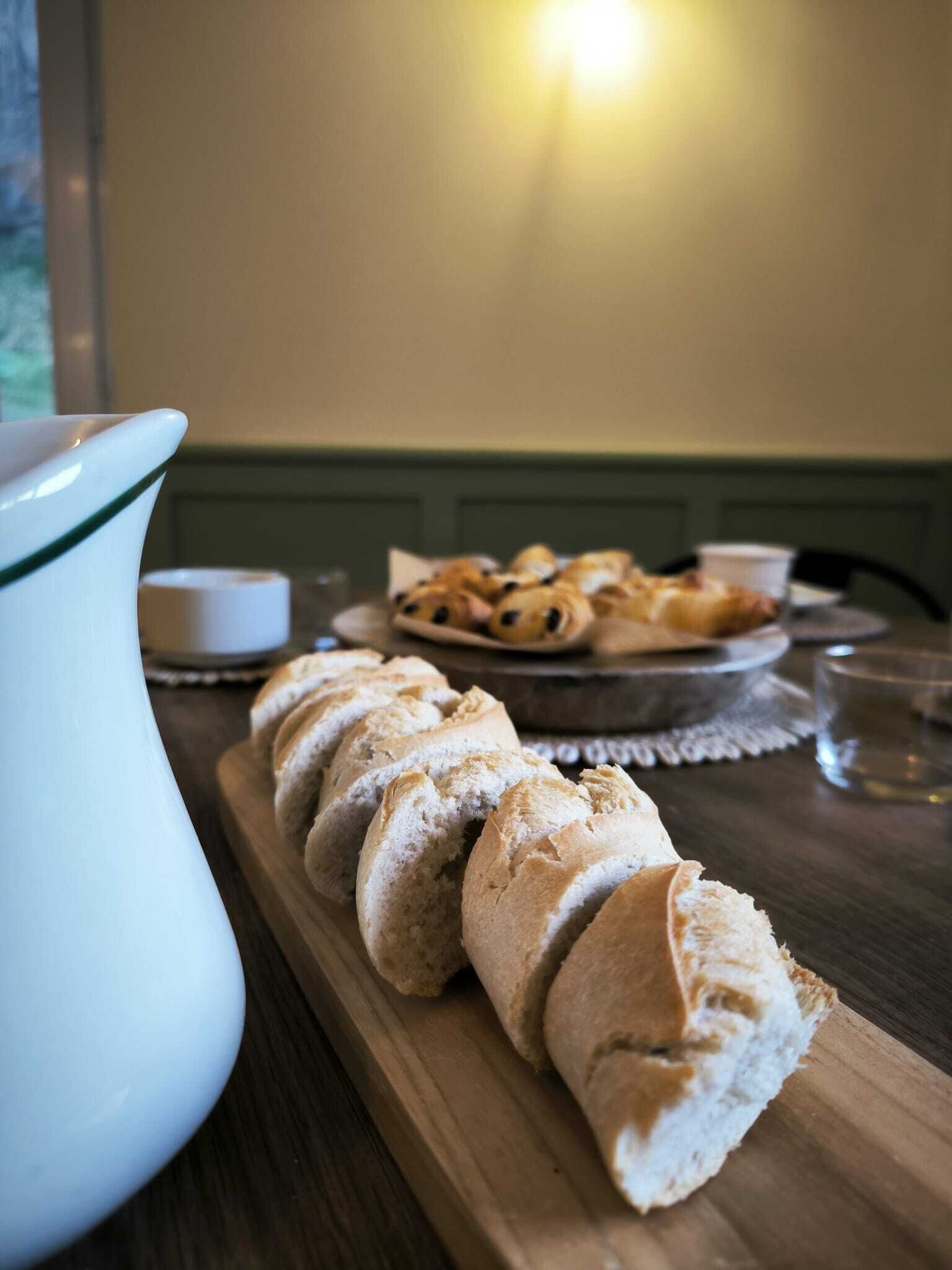 Una tabla de madera con rebanadas de pan y una jarra de agua sobre una mesa.