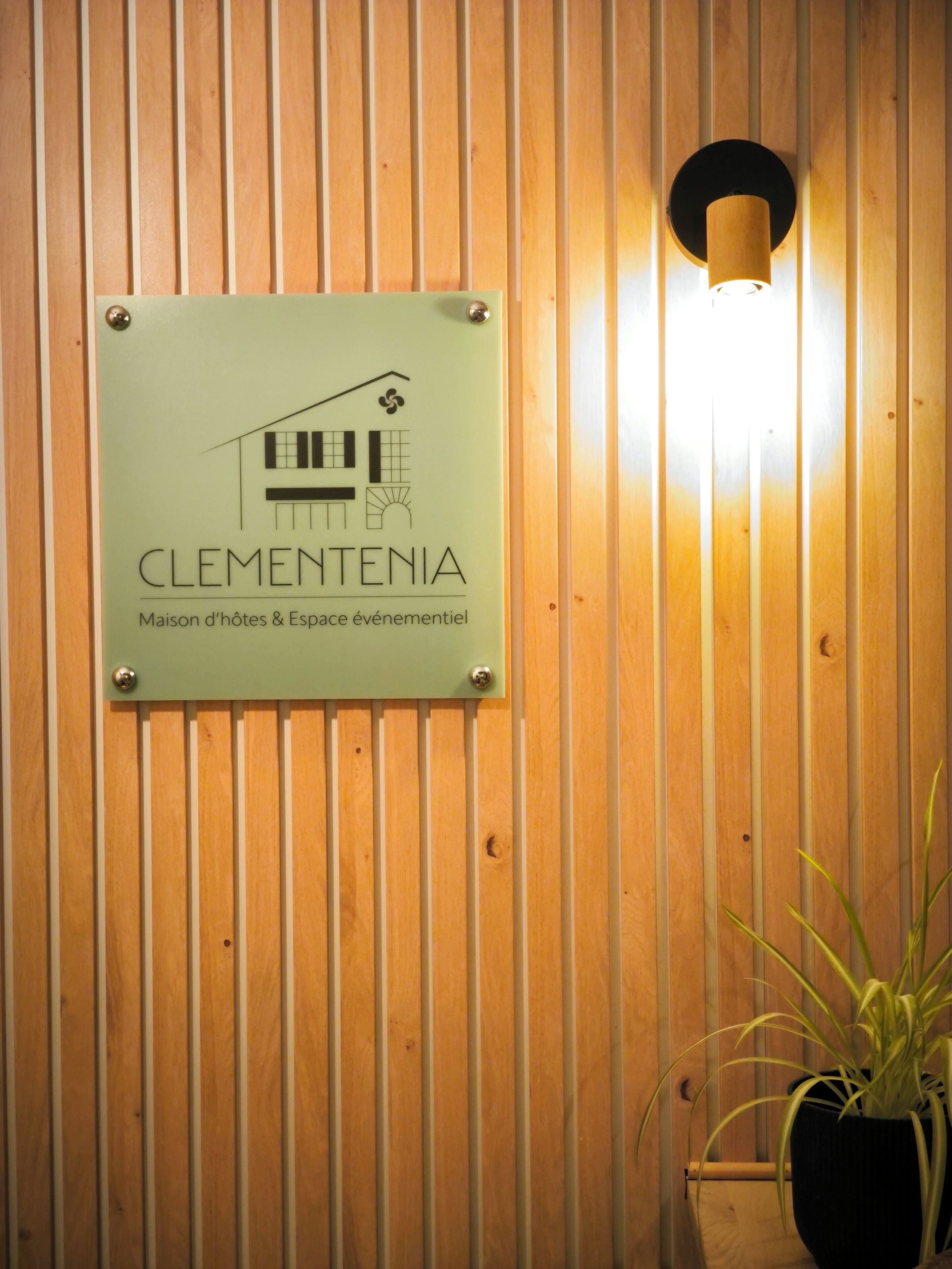 Un cartello con il nome 'Clementenia' e la descrizione della proprietà come casa e spazio eventi.