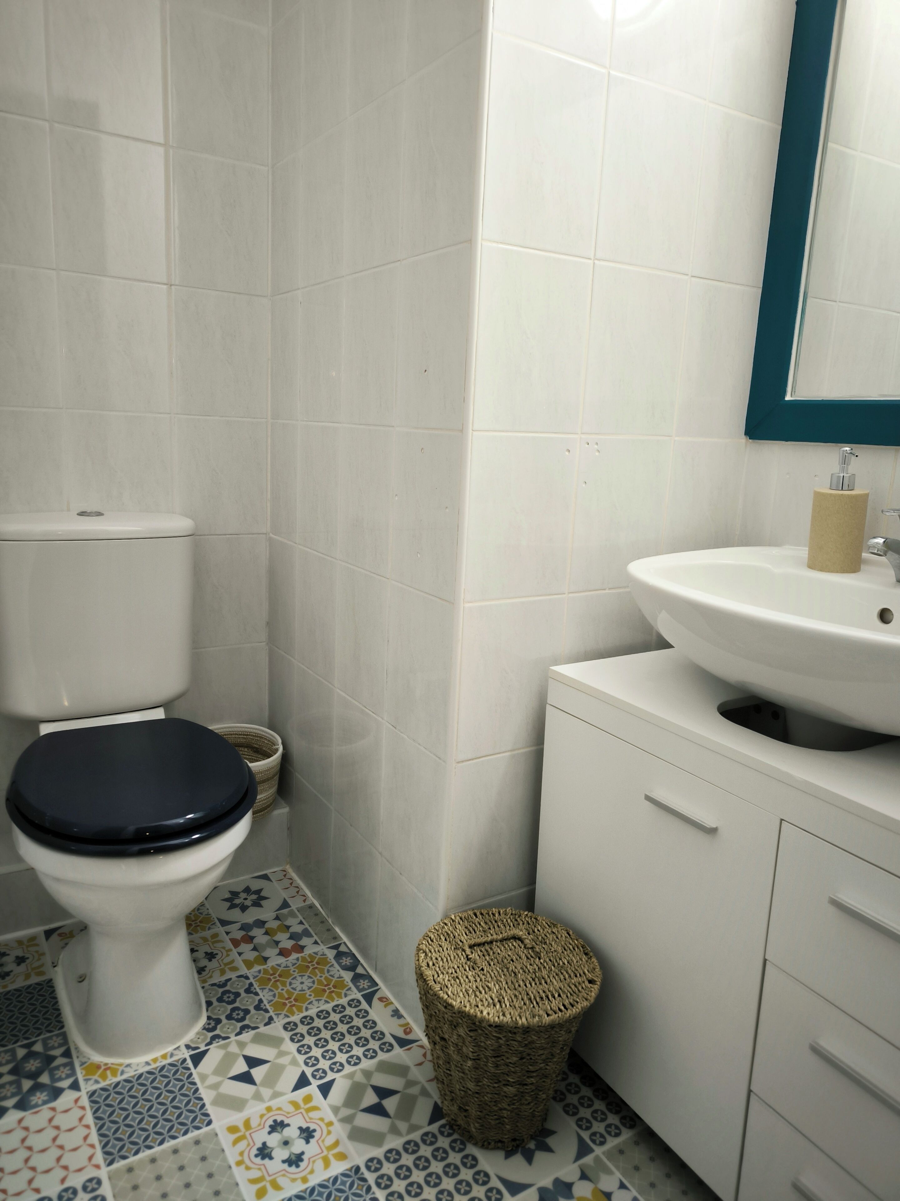 A bathroom with a toilet, a sink, and a tiled floor.