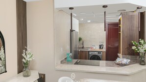 A modern bathroom with a large mirror, a sink, and a toilet. There is a vase with flowers on the counter and a small plant beside the mirror. - Sokon Residence Nile View at Hilton (Cairo)