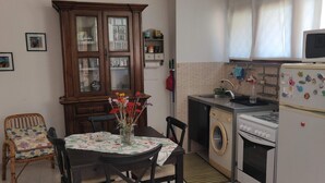 A compact kitchen with a dining area, a washing machine, and a microwave.
