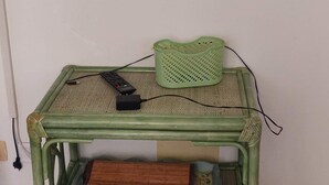 A green metal TV stand with a flat-screen TV mounted above it.
