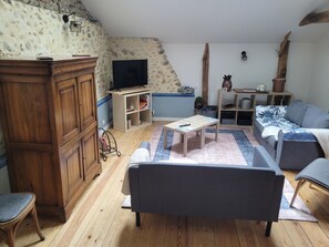Ein Wohnzimmer mit einem Holzschrank, einem Fernseher, einem Sofa und einem Couchtisch.