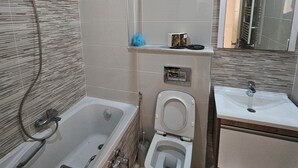 Un baño moderno con bañera, inodoro y lavamanos.