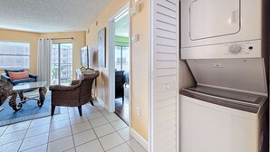 Ein Wohnzimmer mit einer Couch, einem Sessel, einem Couchtisch und einem großen Fenster.