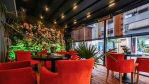 A restaurant with red chairs and a green-lit wall. - Capital Inn Tirana (Tirana)