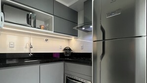 A modern kitchen with stainless steel appliances, including a refrigerator, oven, and microwave.