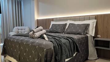 A modern bedroom with a large bed, a bedside table, and a headboard.