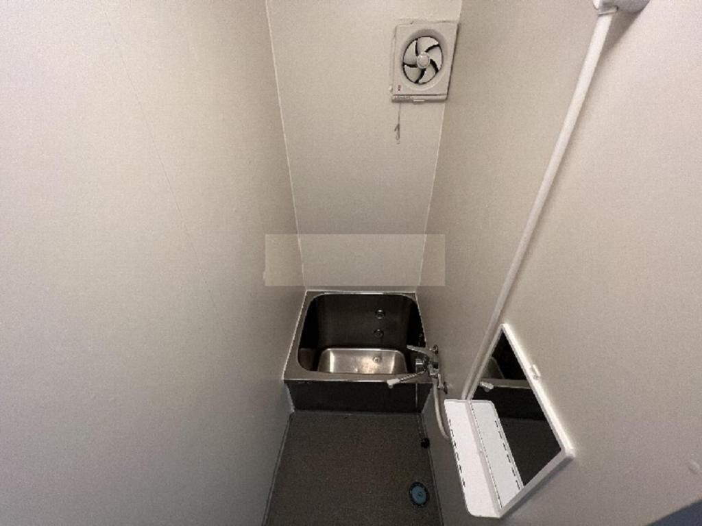 Pieni kylpyhuone, jossa on pesuallas, wc ja suihkutila.