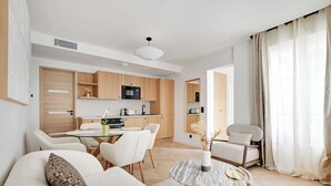 A modern living room with a sofa, coffee table, and dining area. - Charming Apartment - AC- 3br-6p- Montorgueil (Paris)