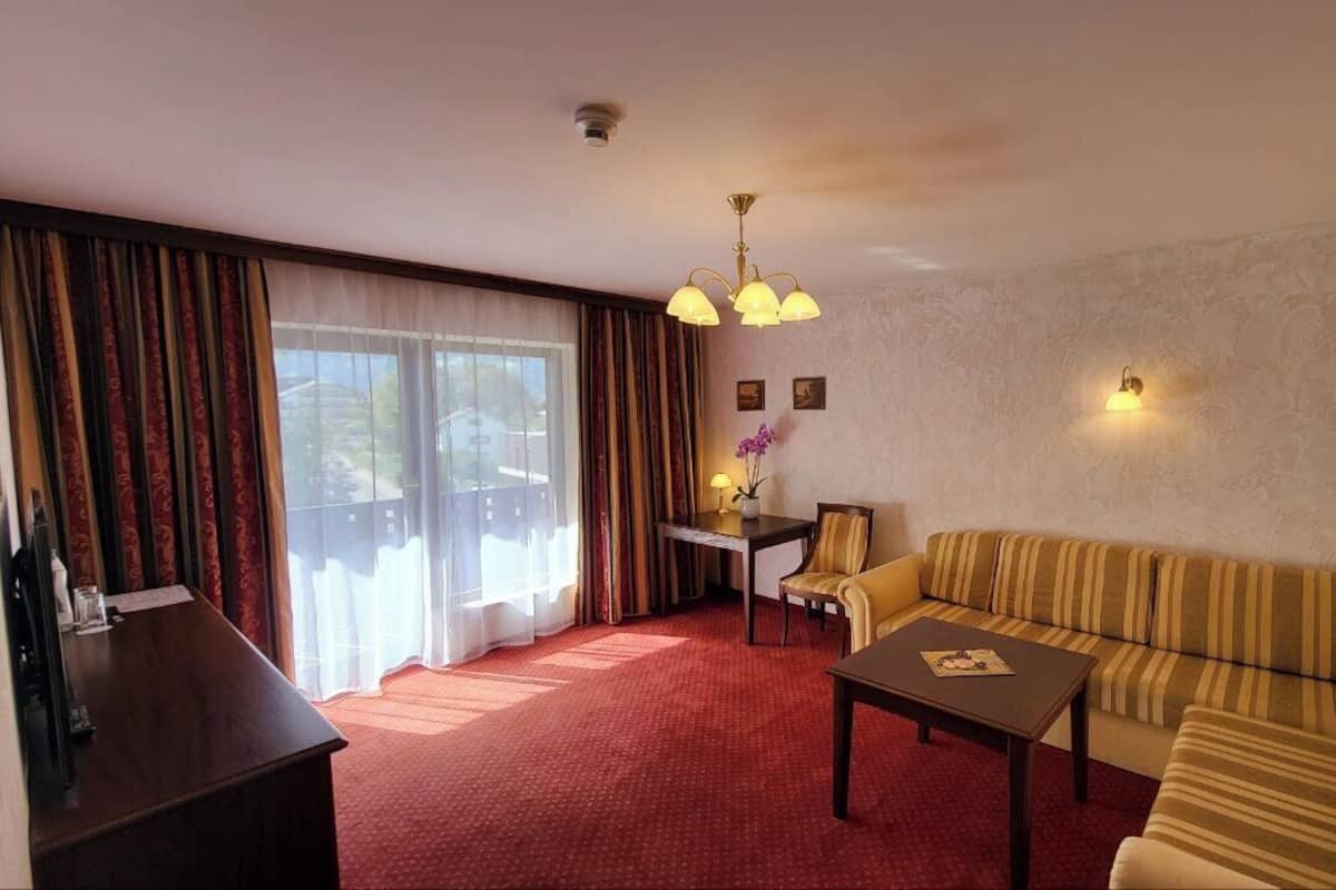 Suite, 1 camera da letto, balcone, vista montagna | Area soggiorno | TV a schermo piatto