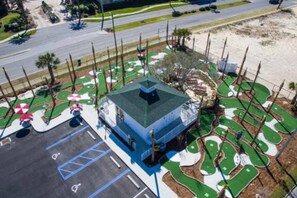 Un bâtiment avec un toit bleu et un parking avec des places délimitées.