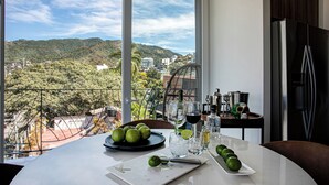 Mesa de comedor con vistas a un paisaje montañoso a través de amplios ventanales.