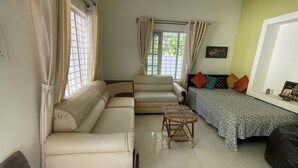 A living room with a sofa, armchair, and a small table.