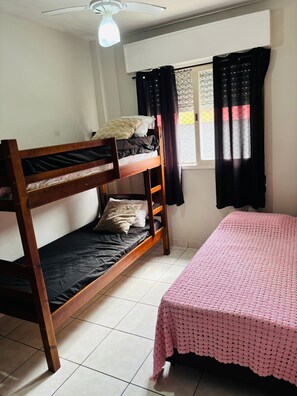 Cozy room with a bunk bed and single bed, featuring a window and ceiling fan.