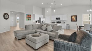 A modern living room with a sectional sofa, a coffee table, and a patterned armchair. - Serene Stay in Savannah`s Residential Heaven (Savannah)