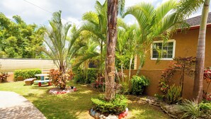 A well-maintained garden with palm trees, a picnic table, and a small pond. - Cozy 1-bedroom apartment in charming Mandeville with WiFi, AC (Mandeville)