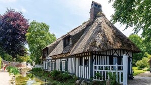A traditional thatched-roof house with a white fence and a small pond in front. - Apartment le Beluga - near the sea - center of Veules-Les-Roses (Veules-les-Roses)
