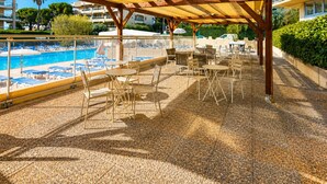 A covered outdoor area with a pool, lounge chairs, and tables. - Villa Bono Romantic Suite & Private Jacuzzi (Saint-Laurent-du-Var)