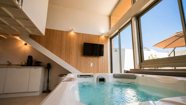 A modern indoor swimming pool with a wooden wall and a television mounted above it. - Villa Bono Romantic Suite & Private Jacuzzi (Saint-Laurent-du-Var)