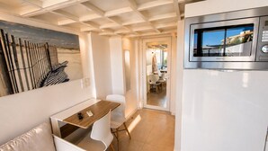 A modern kitchen with a built-in refrigerator, a dining area with a table and chairs, and a view of the dining area through a glass door. - Villa Bono Romantic Suite & Private Jacuzzi (Saint-Laurent-du-Var)