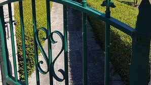 A house with a green metal gate, a paved driveway, and a well-maintained lawn. - Bed and breakfast 15 minutes from Saumur (Vernantes)