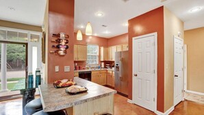 A modern kitchen with a central island, wooden cabinets, and pendant lighting. - Relax with the whole family at this peaceful place to stay. (Memphis)
