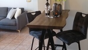 A dining area with a wooden table, two black chairs, a bottle of wine, two wine glasses, and a candle. - Cozy, bright apartment in a very quiet location (Detmold)