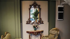 A room with a patterned floor, a large mirror, two ornate chairs, and a small table with a laptop. - Leila Mansion Hotel (Tekirdag)