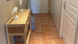A hallway with a wooden desk, a mirror, and a white door. - Appart. T2 Les Issambres 400 m from beaches and port (Roquebrune-sur-Argens)