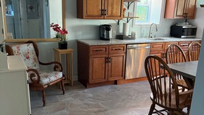 A kitchen with wooden cabinets, a coffee maker, and a microwave.