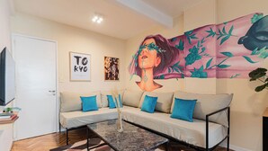 Un salon avec un canapé, une table basse et une fresque murale.