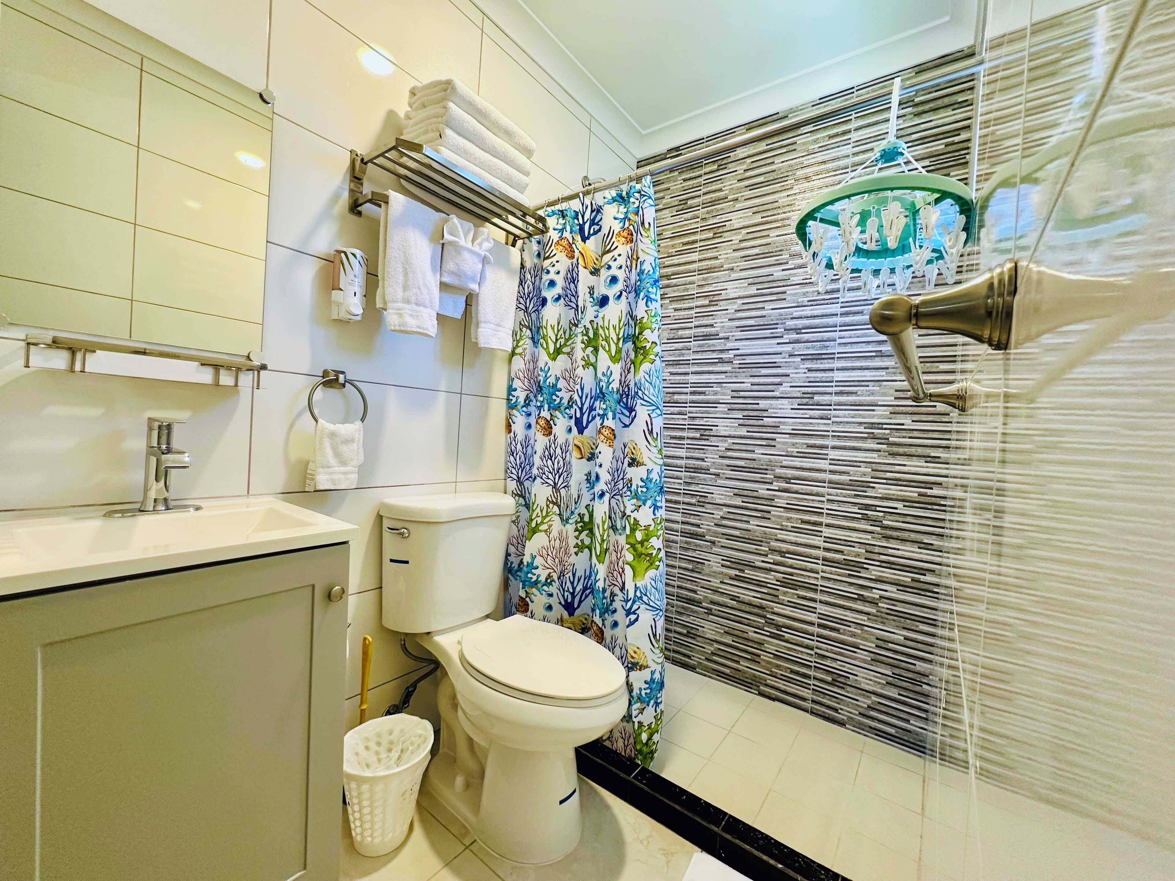 A bathroom with a toilet, sink, and shower area.