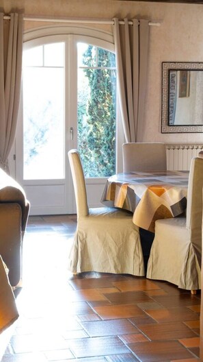 Enjoy a peaceful stay with a view of lush greenery from the large window, a dining table for meals, and a comfortable seating area.