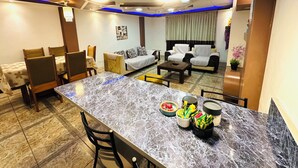 Una sala de estar moderna con una mesa de comedor de mármol, sofás y una mesa auxiliar.