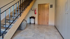 Un escalier avec une rampe noire menant à un palier.
