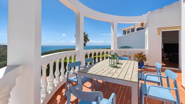 A terrace with a table and chairs, overlooking a scenic view.