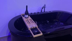 A modern bathroom with a large flat-screen TV mounted on the wall displaying a Netflix profile. - Magnificent Imperial suite for 2 people breakfast included free prosecco (Palermo)