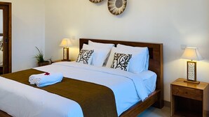 Ein modernes Schlafzimmer mit einem hölzernen Bett, weißer Bettwäsche, Wandkunst und Nachttischlampen.