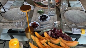 A dining table set with plates, bowls, and cutlery, surrounded by chairs. - Uzès, 30 minutes from Mas d'Angel, at Éric & France (Cornillon)