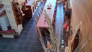 A wooden interior with a long dining table and chairs, a fireplace, and a view of the outdoors. - Large gîte for 14 people with hot tub & fireplace 🌲 Nature, forest & relaxation (raon sur plaine)