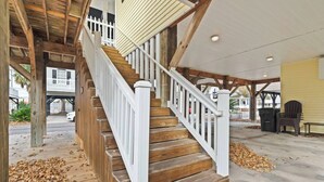 A wooden staircase with white railings leading to a covered porch area. - Branch Breeze - Golf Cart | Linens | Ocean Lakes (Myrtle Beach)