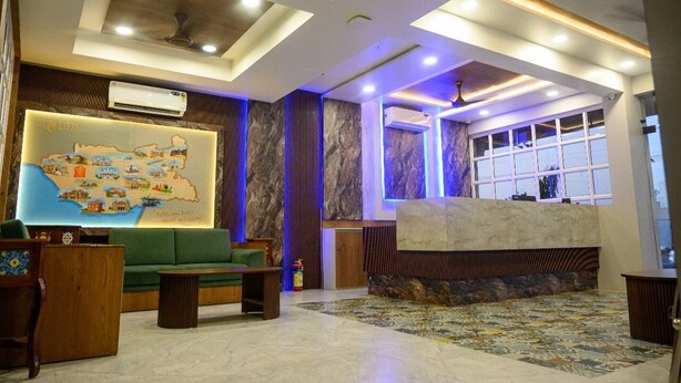 A lobby with a green sofa, a map mural, and a reception desk.